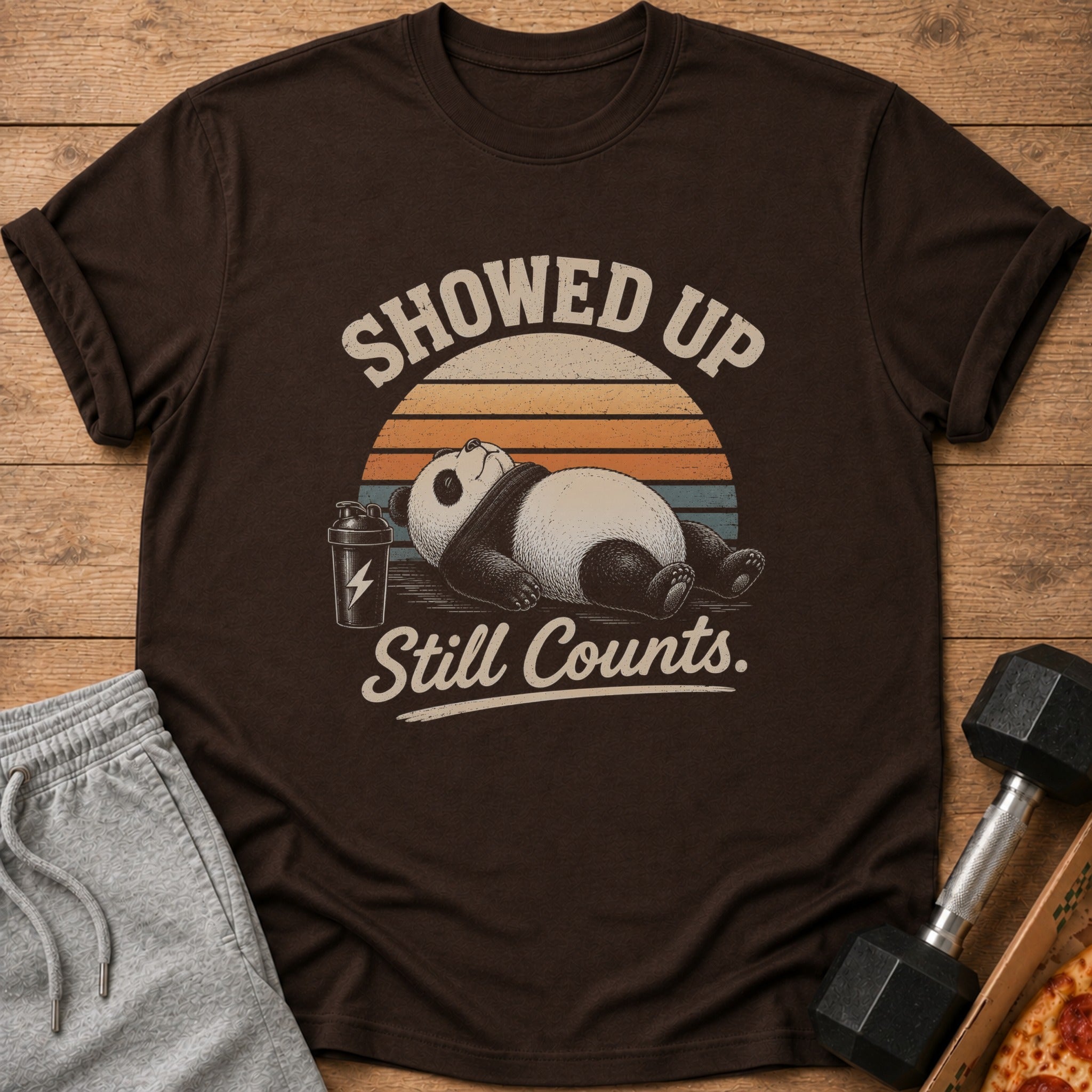 Brown t-shirt with a panda, shaker bottle, and text "Showed Up Still Counts."