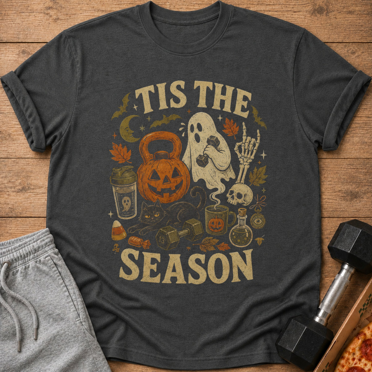 Dark t-shirt with Halloween-themed fitness graphics and text "TIS THE SEASON".