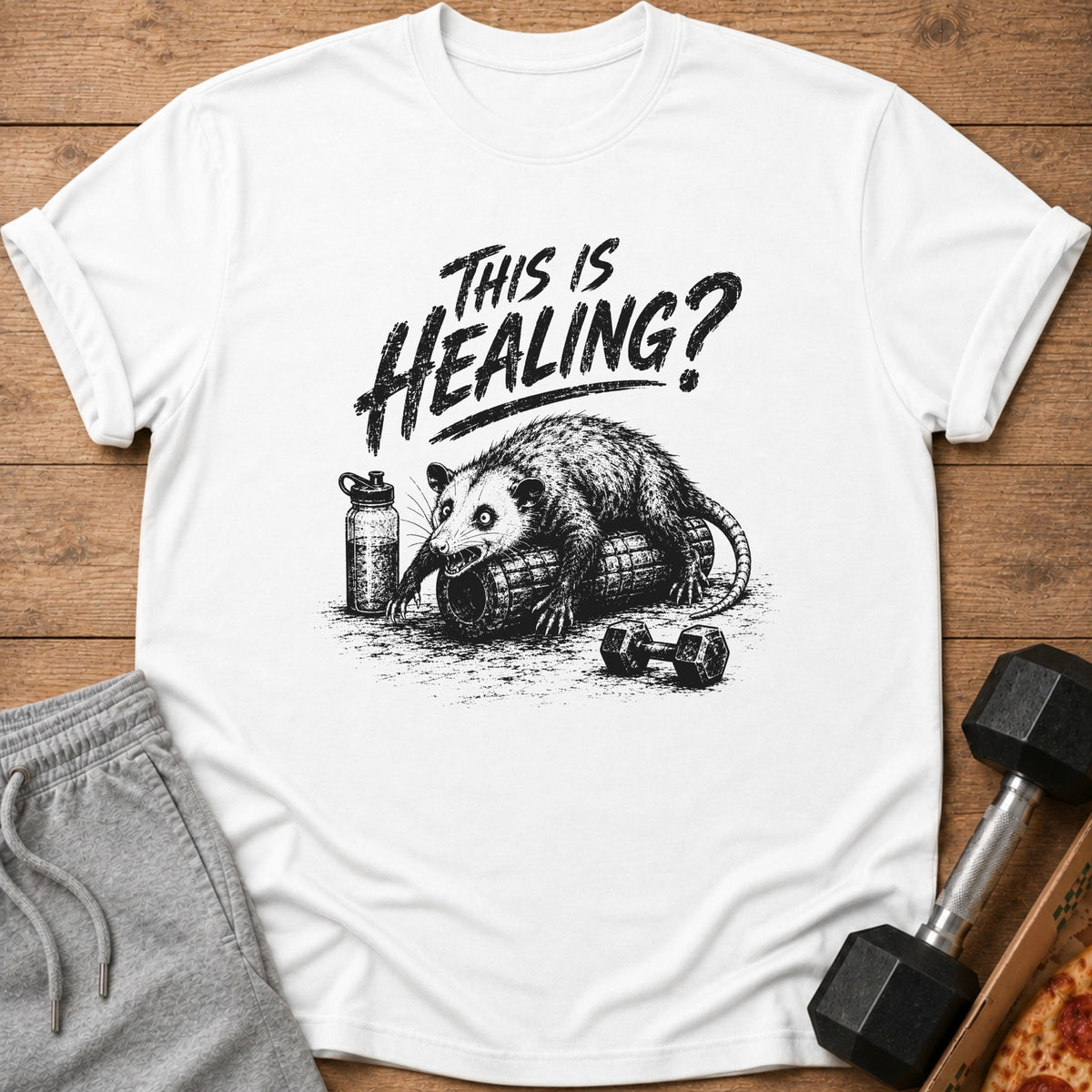 T-shirt with opossum on foam roller and "This is Healing?" text.