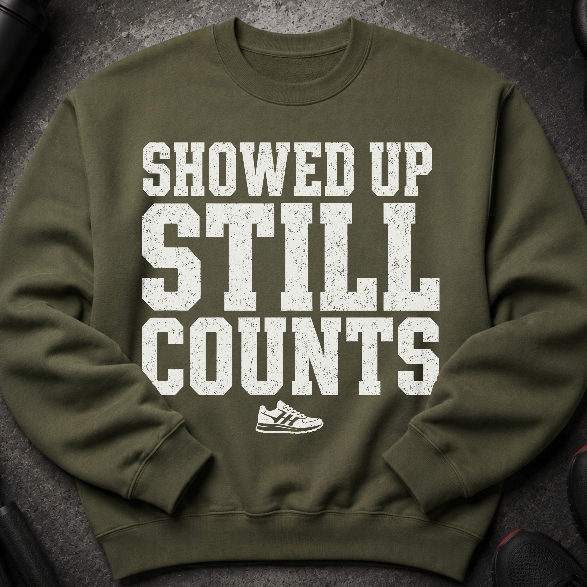 Olive green sweatshirt with white text: SHOWED UP STILL COUNTS and a sneaker graphic.