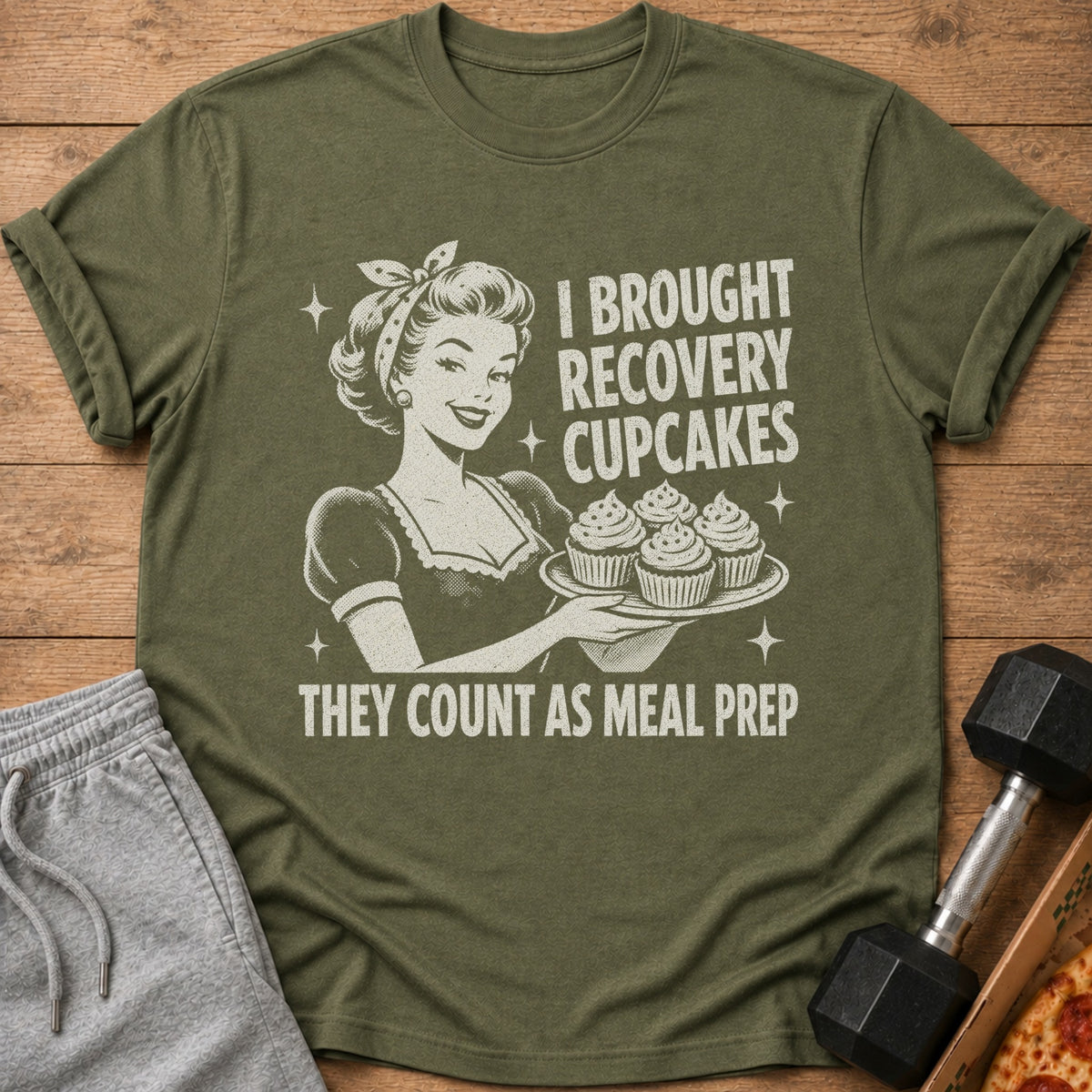 Olive t-shirt with retro illustration and text: "I BROUGHT RECOVERY CUPCAKES THEY COUNT AS MEAL PREP"