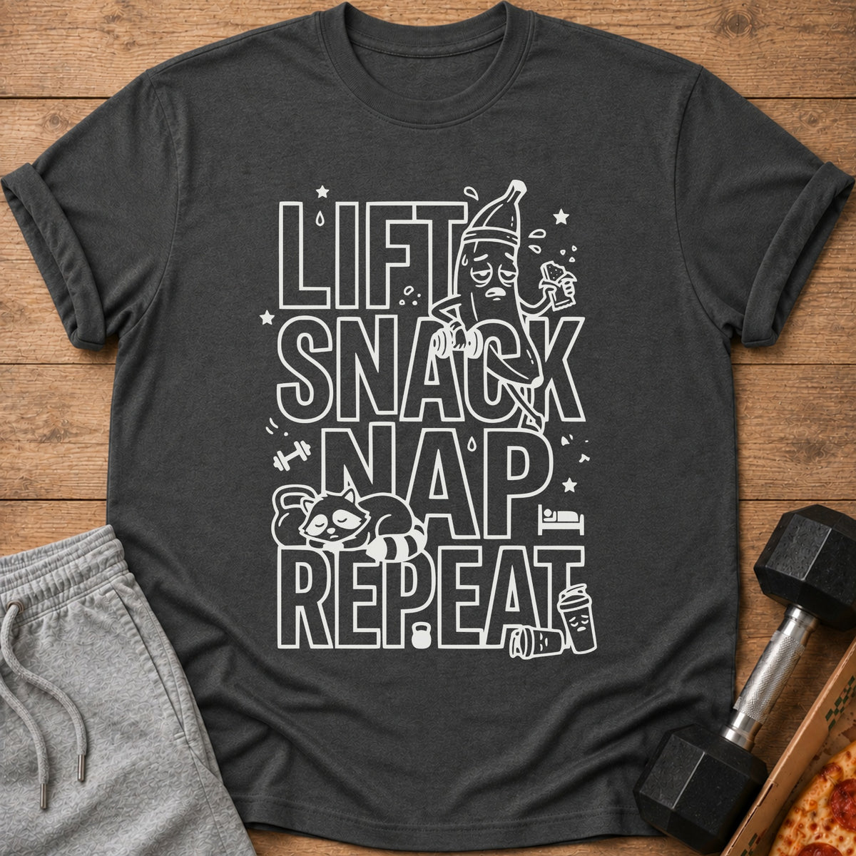 Dark grey t-shirt with white text: Lift Snack Nap Repeat, and cartoon graphics.