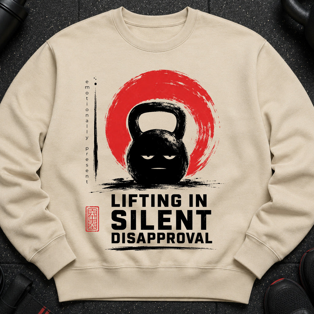 Cream sweatshirt with a black kettlebell design and text "LIFTING IN SILENT DISAPPROVAL".