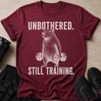Maroon t-shirt with a capybara lifting dumbbells, text reads "UNBOTHERED. STILL TRAINING."