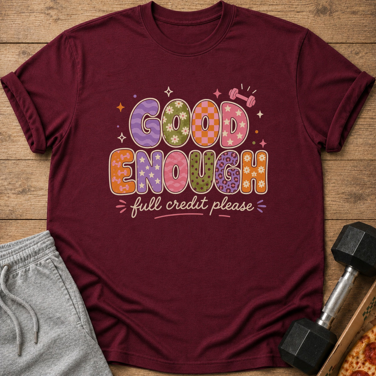Maroon t-shirt with "Good Enough" and "full credit please" text in colorful, patterned letters.