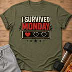 Green t-shirt with "I survived Monday" text and pixelated hearts.