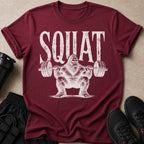 Maroon t-shirt with white distressed graphic of Bigfoot squatting with a barbell.