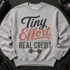 Grey sweatshirt with "Tiny Effort, Real Credit" text and dumbbell graphic.