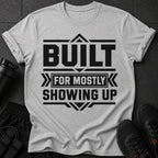 Light grey t-shirt with black text reading "BUILT FOR MOSTLY SHOWING UP."