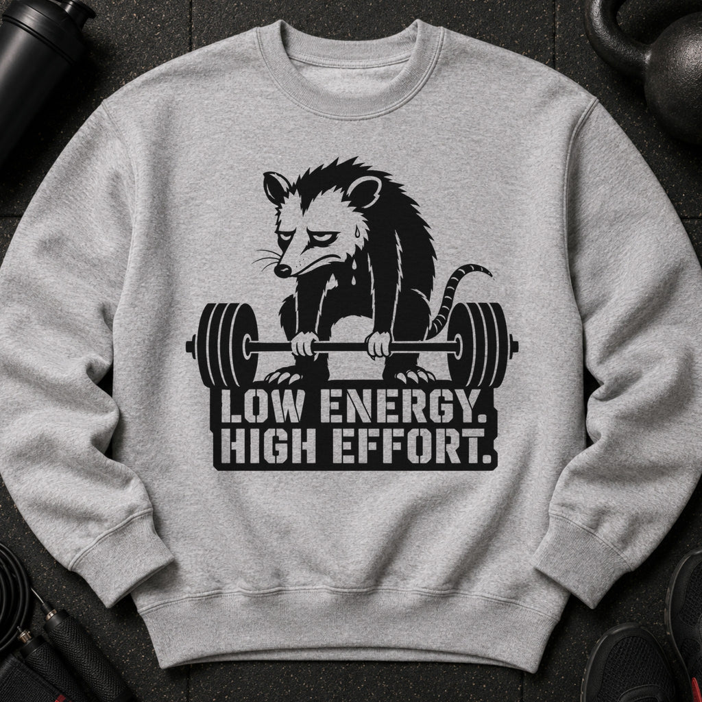Grey sweatshirt with a black graphic of a sad opossum lifting a barbell and text.