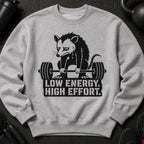 Grey sweatshirt with a black graphic of a sad opossum lifting a barbell and text.