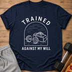 Navy t-shirt with white text "TRAINED AGAINST MY WILL" and gym bag with barbell illustration.