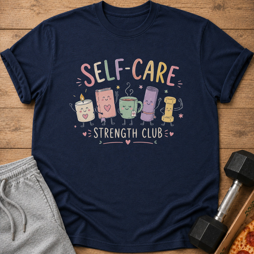 Navy t-shirt with "SELF-CARE STRENGTH CLUB" and cartoon candle, book, mug, yoga mat, bolt.