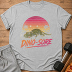 Grey t-shirt with a distressed graphic of a tired dinosaur and text "DINO-SORE".