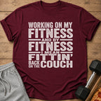 Maroon t-shirt with "Working on my fitness, I mean fittin' back on the couch" text.