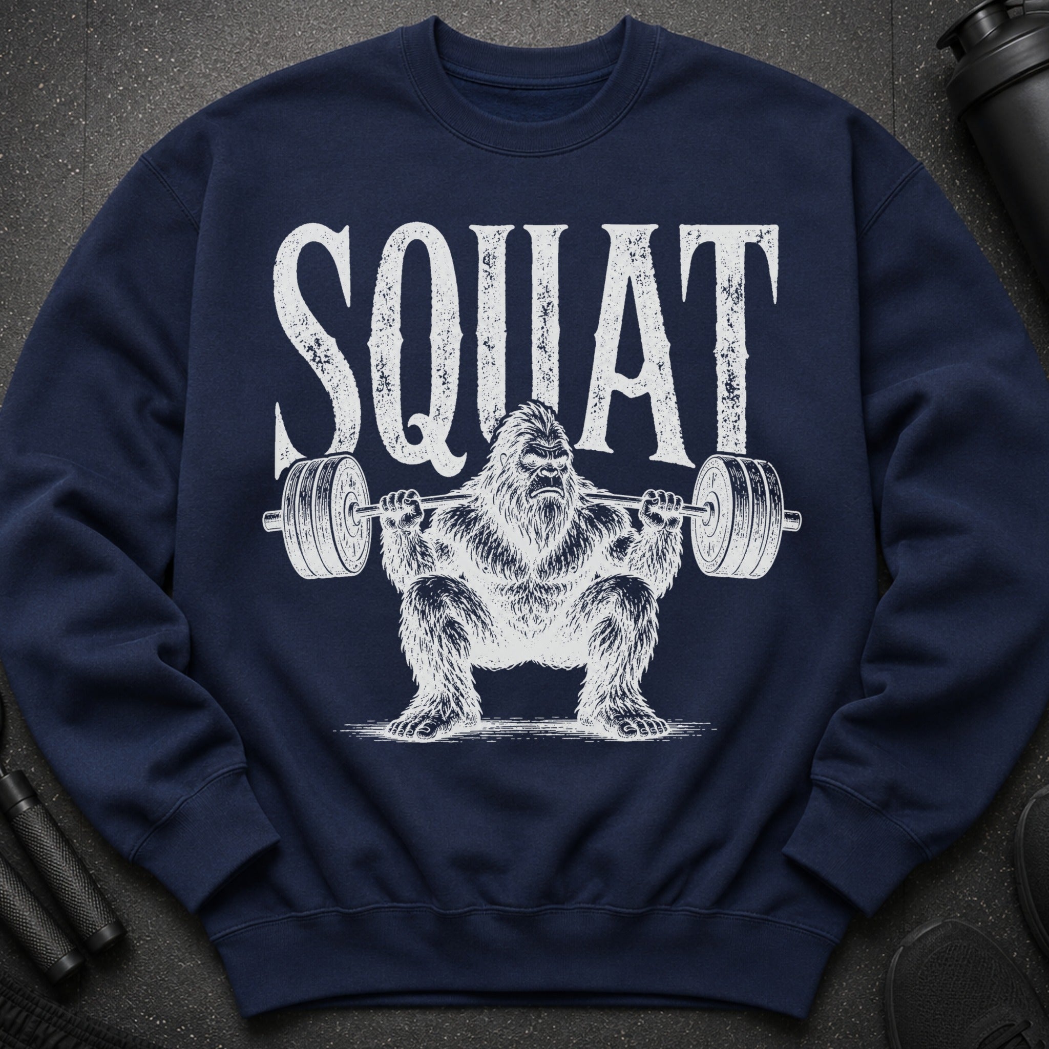 Navy sweatshirt with distressed text "SQUAT" and Bigfoot lifting weights.