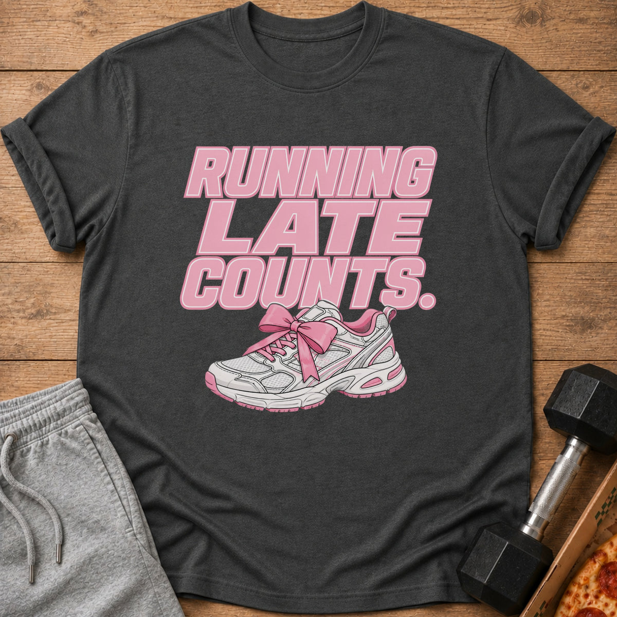 T-shirt with pink text "RUNNING LATE COUNTS" and a pink-bowed sneaker.
