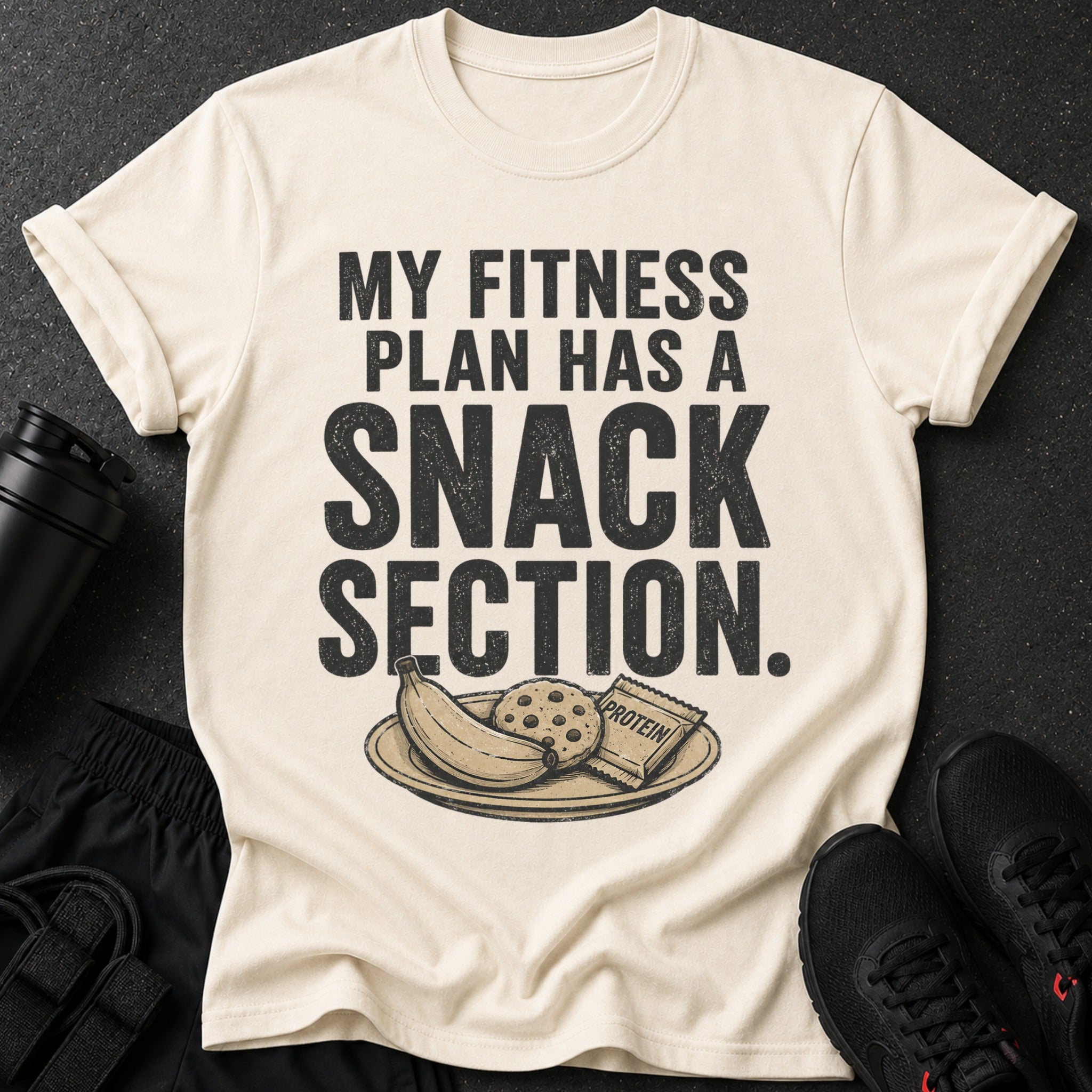 Cream t-shirt with "MY FITNESS PLAN HAS A SNACK SECTION" text and snacks.