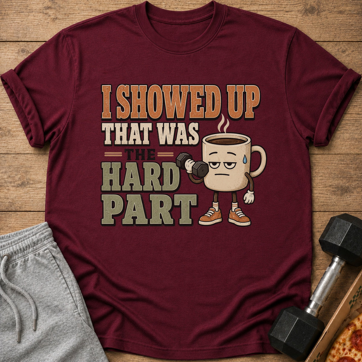 Maroon t-shirt with a cartoon coffee cup lifting weights and text "I showed up that was the hard part".