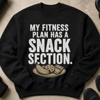 Black sweatshirt with text "MY FITNESS PLAN HAS A SNACK SECTION" and illustration.