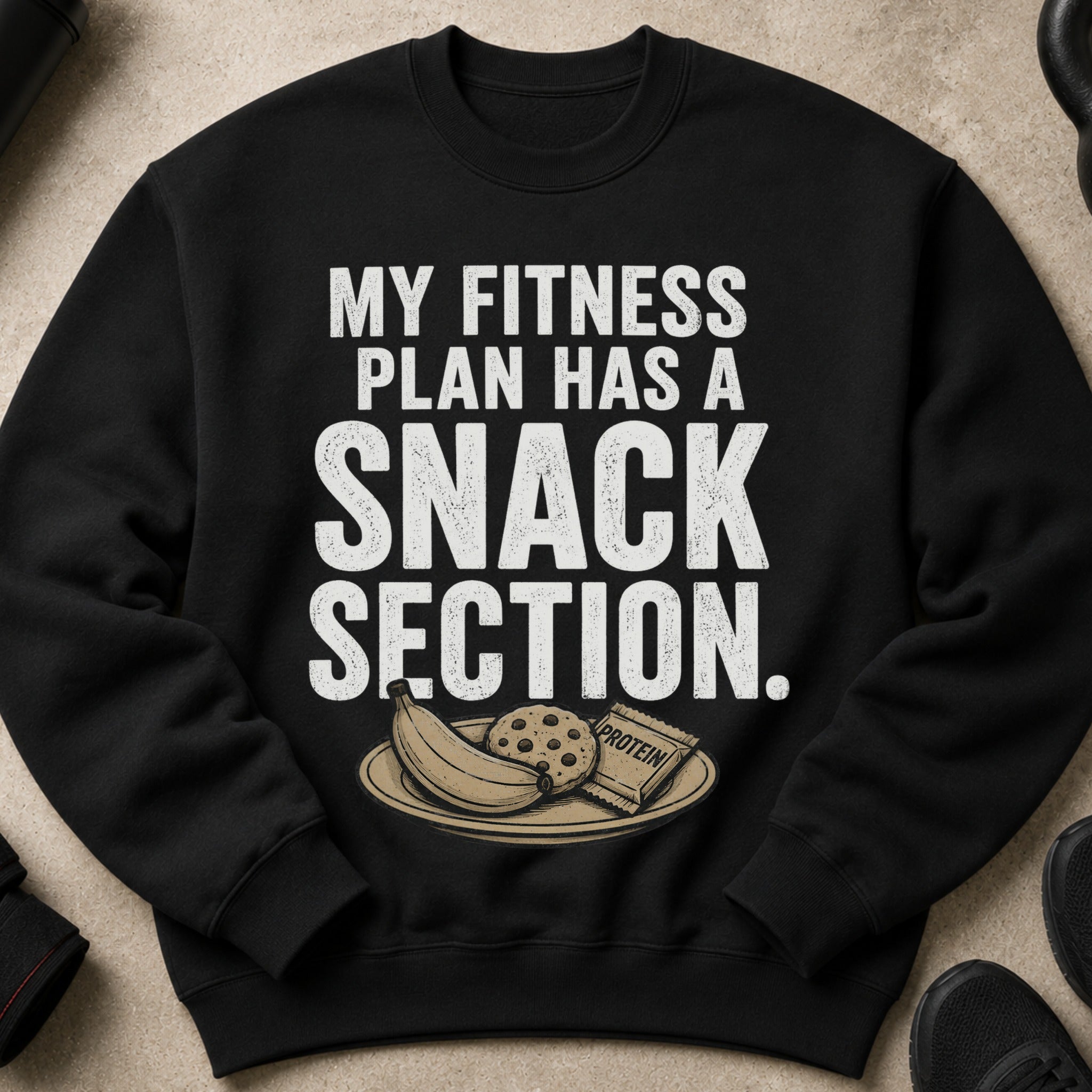 Black sweatshirt with text "MY FITNESS PLAN HAS A SNACK SECTION" and illustration.