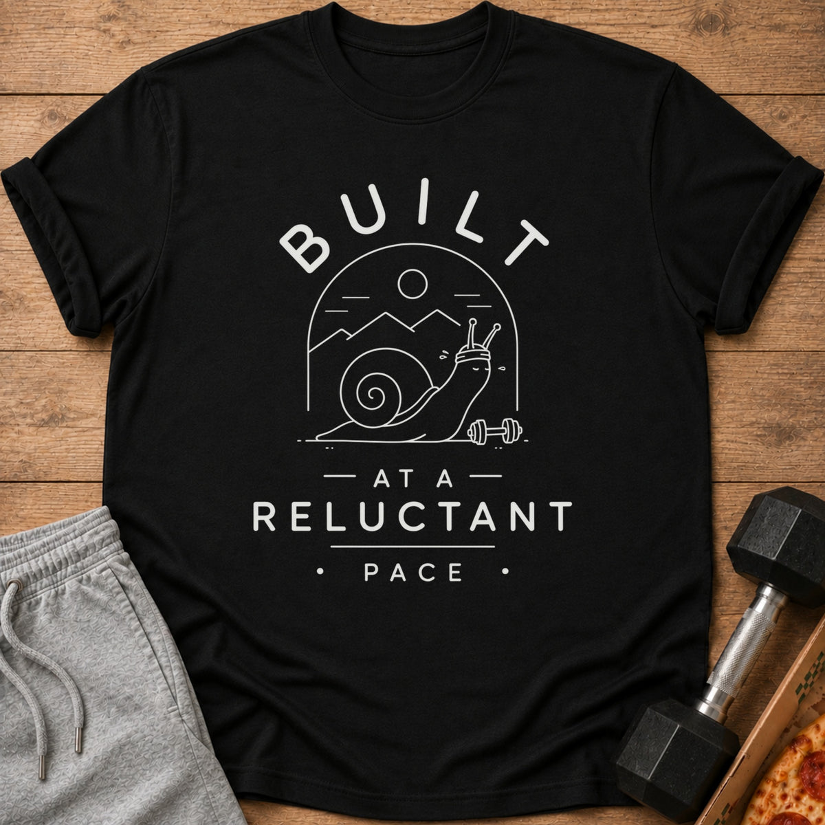 Black t-shirt with white text "BUILT - AT A - RELUCTANT PACE" and a graphic.