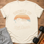 Cream t-shirt with text "Showed Up Still Counts" and a sleeping panda graphic.