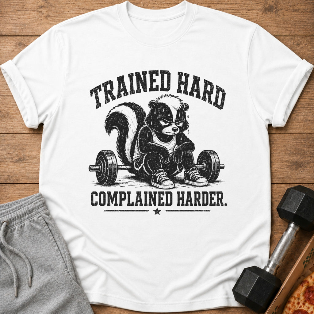 White t-shirt with a skunk lifting weights and text "TRAINED HARD COMPLAINED HARDER."