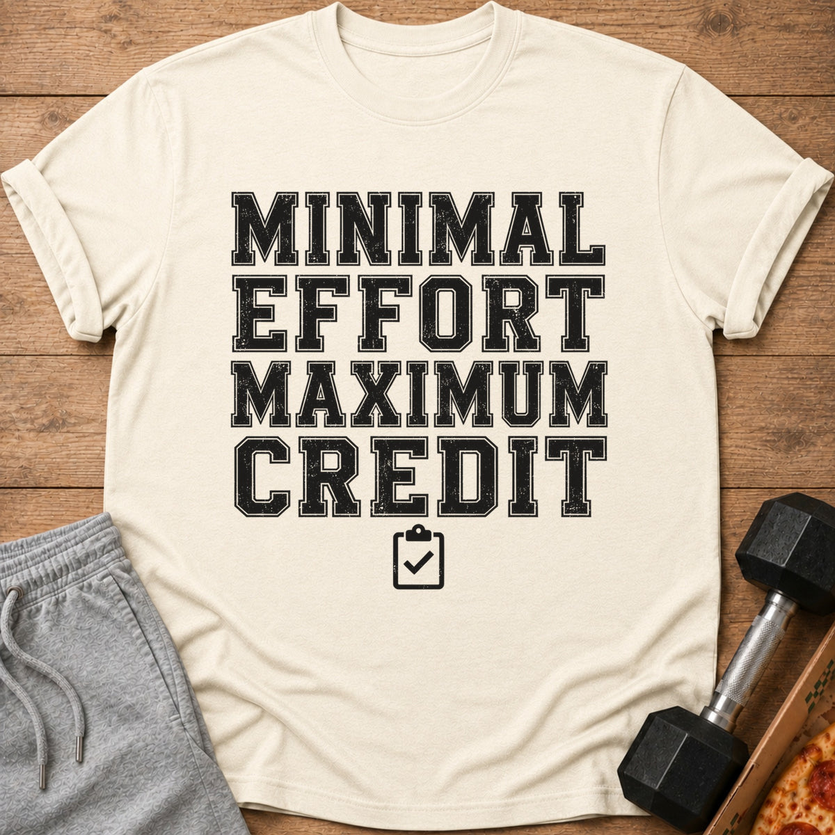 Cream t-shirt with black text "MINIMAL EFFORT MAXIMUM CREDIT" and a checklist icon.