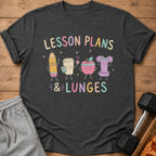 Dark gray t-shirt with cartoon pencil, coffee cup, apple, and dumbbell saying "Lesson Plans & Lunges".