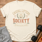 Cream t-shirt with "CASUAL LIFTERS SOCIETY" text, a sloth, and dumbbells graphic.