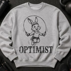Grey sweatshirt with a drawn bunny skipping rope and the word "OPTIMIST" below.