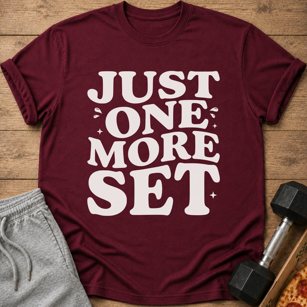 Maroon t-shirt with white text "JUST ONE MORE SET" and workout accessories.
