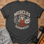 T-shirt graphic of a raccoon wearing a red headband and tank top holding a shopping bag with "Muscles Sold Separately" text.