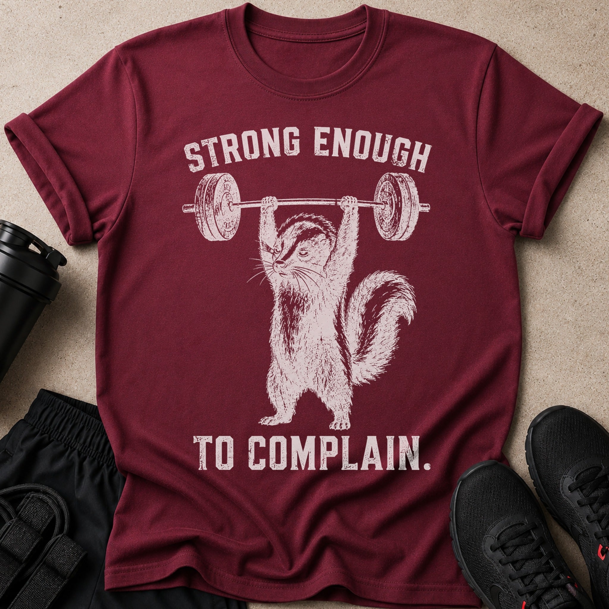 Maroon t-shirt with a graphic of a chipmunk lifting weights and text "STRONG ENOUGH TO COMPLAIN."