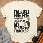 Cream t-shirt with distressed black text and graphics: "I'm Just Here To Disappoint My Fitness Tracker."