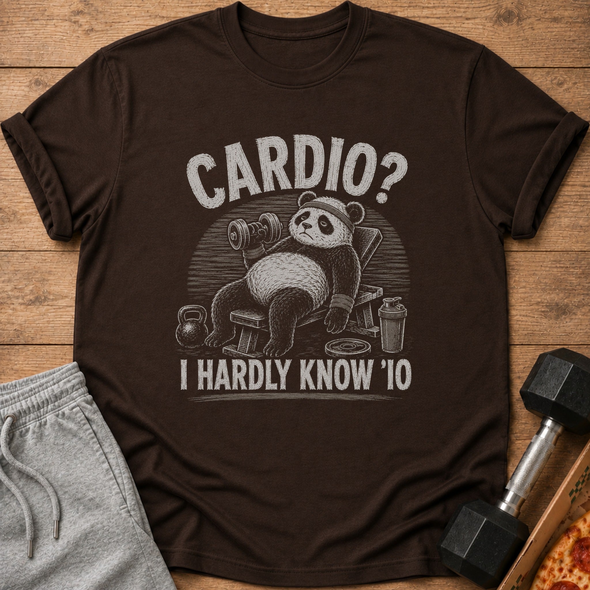 Brown t-shirt with distressed print of a panda on a weight bench holding a dumbbell.
