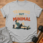 Grey t-shirt with "TRAINING BUT MAKE IT MINIMAL" text and a figure resting with weights.