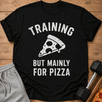 Black t-shirt with white text and a pizza slice graphic: "TRAINING BUT MAINLY FOR PIZZA".
