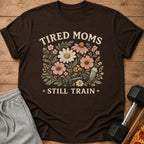 Brown t-shirt with floral graphic and text "TIRED MOMS STILL TRAIN"