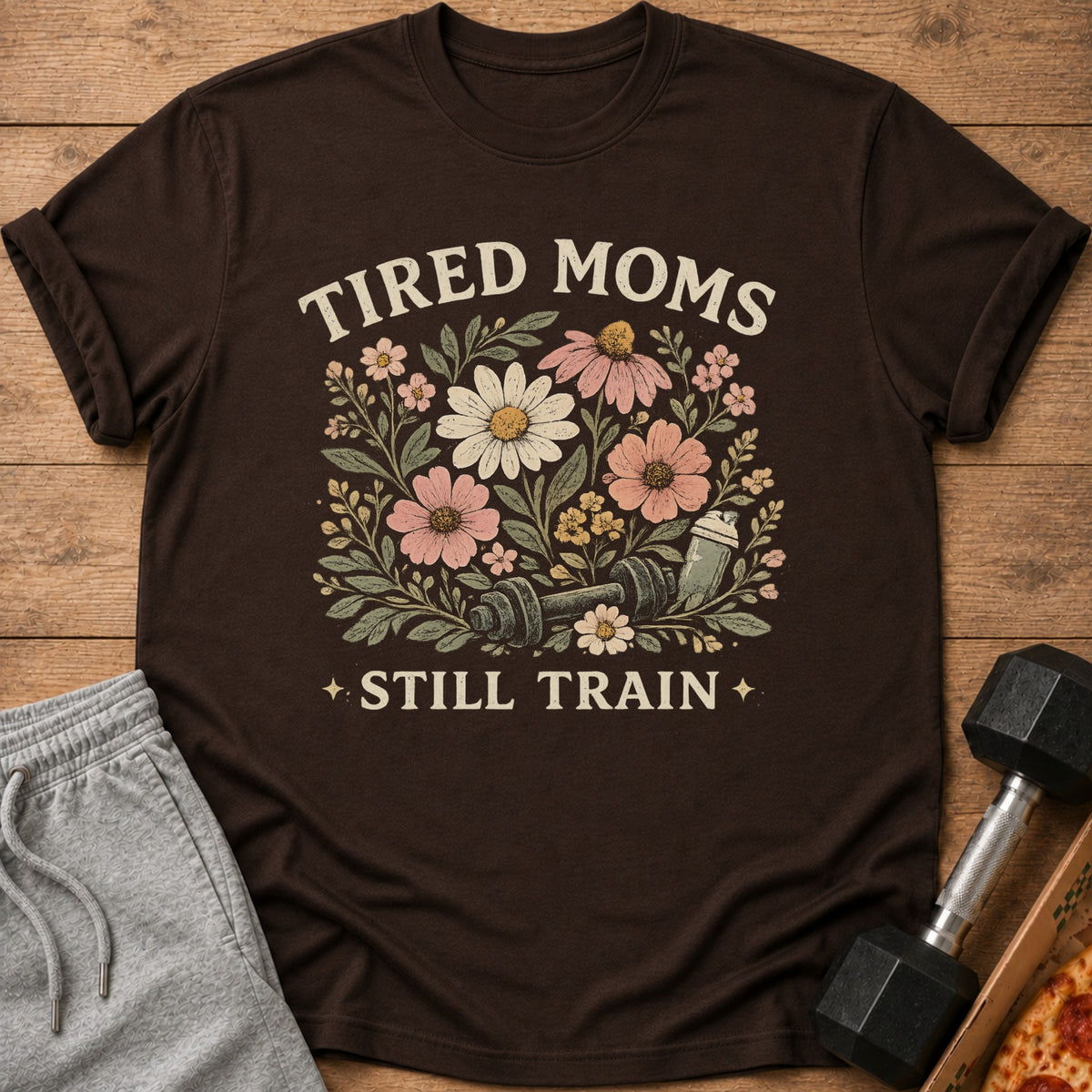 Brown t-shirt with floral graphic and text "TIRED MOMS STILL TRAIN"
