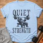 Light blue t-shirt with a gorilla bench pressing and text "QUIET STRENGTH".