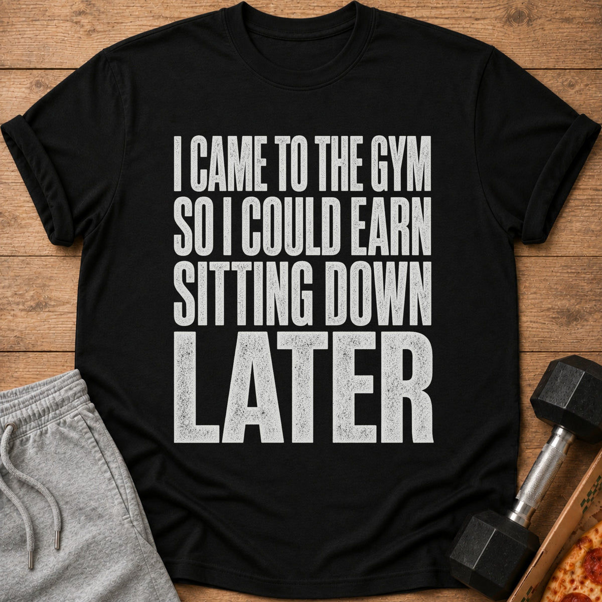 Black t-shirt with white text that reads "I came to the gym so I could earn sitting down later".