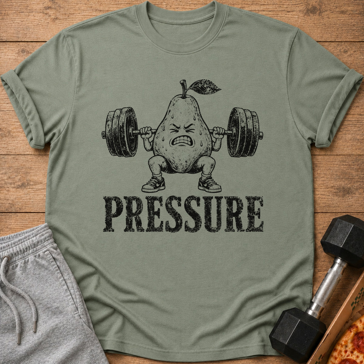 T-shirt with a cartoon pear lifting weights and the word "PRESSURE".