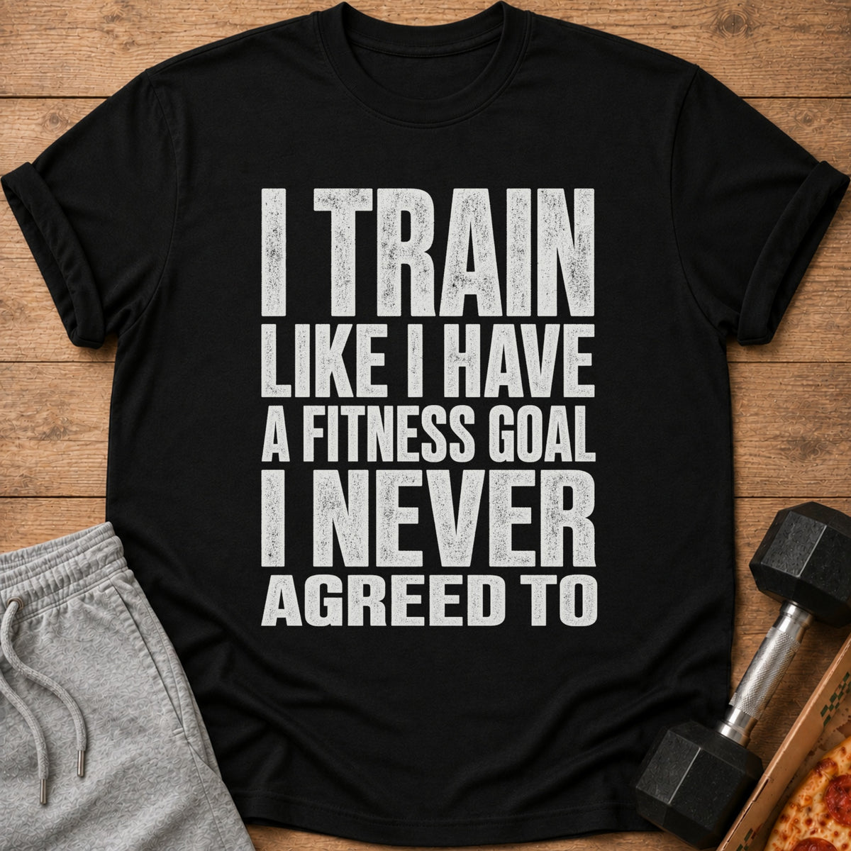 Black t-shirt with white text: "I TRAIN LIKE I HAVE A FITNESS GOAL I NEVER AGREED TO."