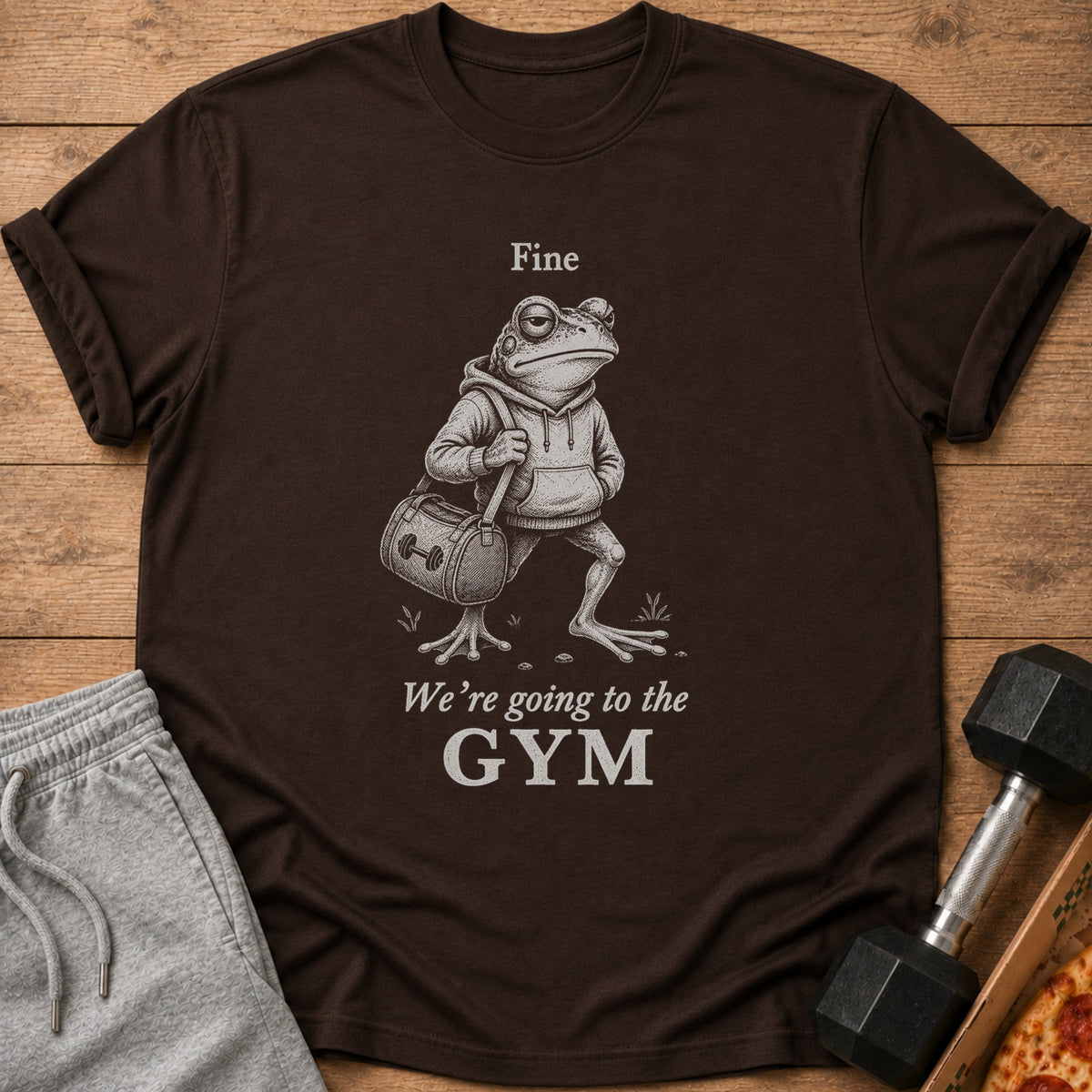 Brown t-shirt with a frog illustration and the text "Fine We're going to the GYM."