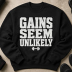 Black sweatshirt with distressed white text "GAINS SEEM UNLIKELY" and dumbbell graphic.