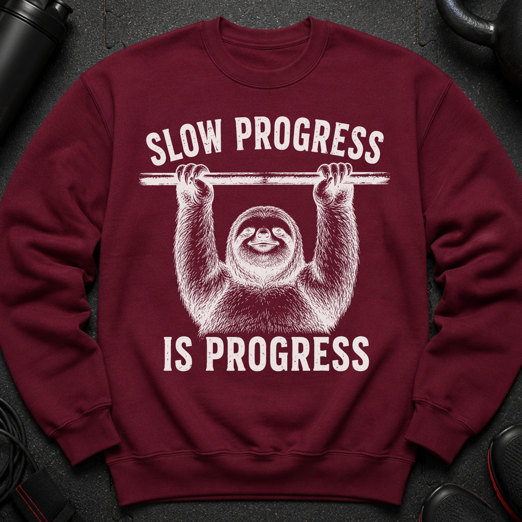 Maroon sweatshirt with graphic of a sloth holding a barbell and the text "SLOW PROGRESS IS PROGRESS".