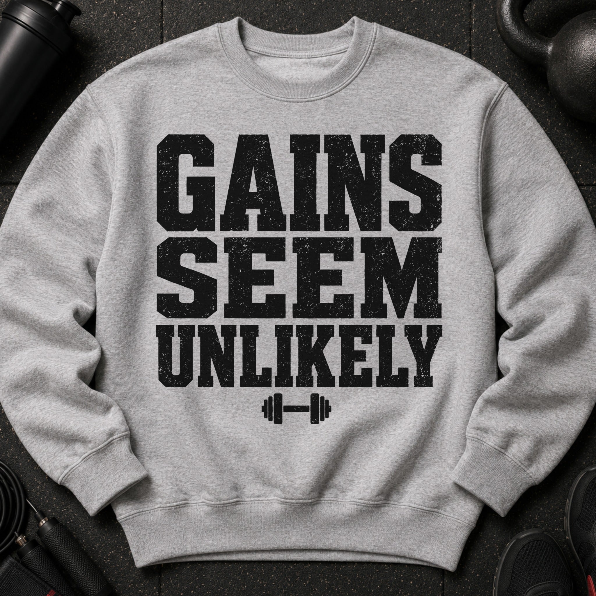 Grey sweatshirt with black distressed text "GAINS SEEM UNLIKELY" and dumbbell graphic.