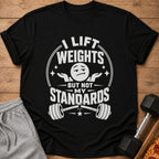Black t-shirt with text "I lift weights but not my standards" and barbell graphic.